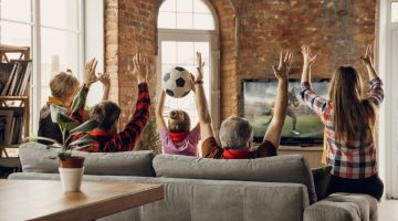 família no sofá assistindo partida de futebol, referente a regulamentação de bets no Brasil